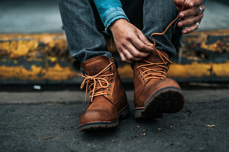 Homme laçant ses bottines en cuir