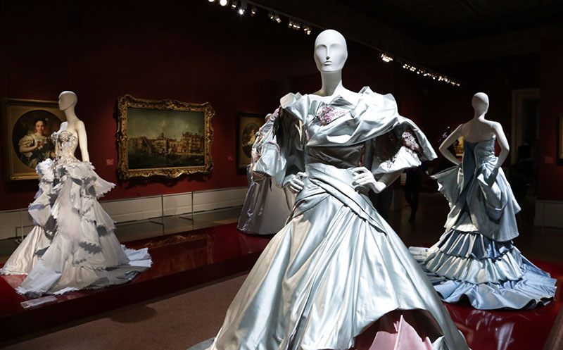 Trois modèles en robes dans un musée